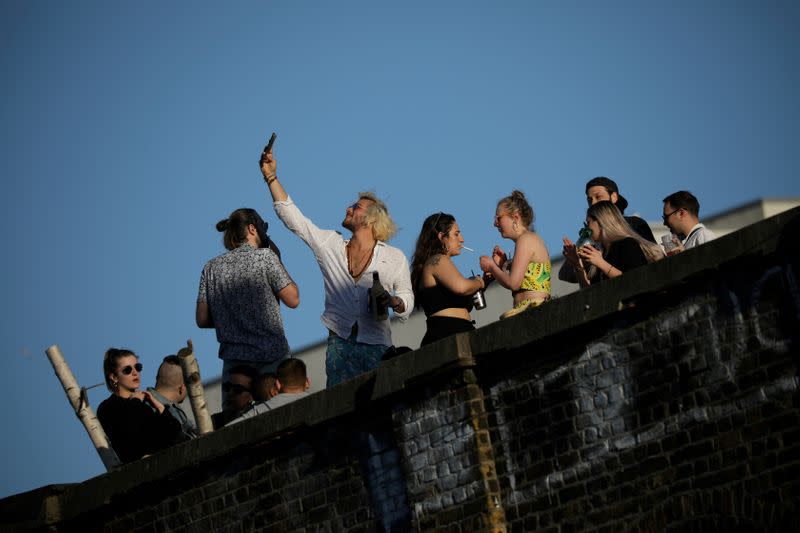 FILE PHOTO: People enjoy warm weather on a rooftop in London