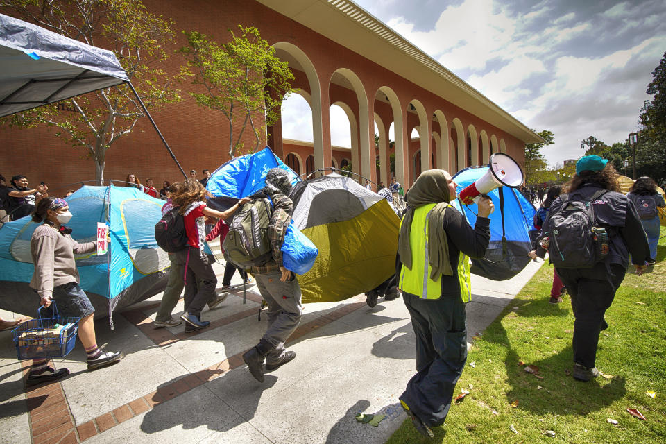 University of Southern California protesters carry a tents around Alumni Park on the University of Southern California to keep security from removing them during a pro-Palestinian occupation on Wednesday, April 24, 2024 in Los Angeles. (AP Photo/Richard Vogel)