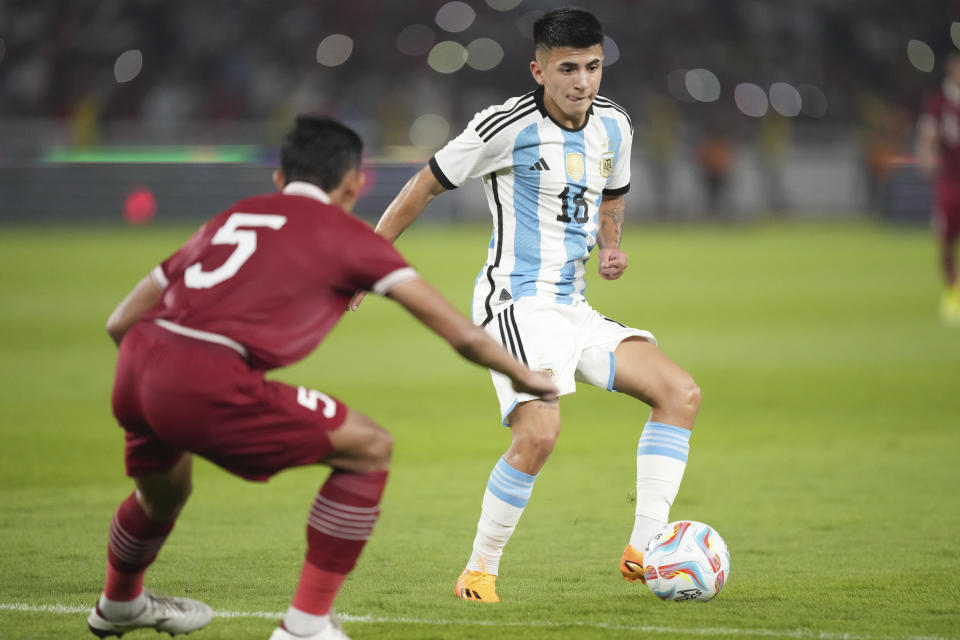 El atacante argentino Thiago Almada (derecha) ante el indonesio Rizky Ridho Ramadhani durante un partido amistoso, el lunes 19 de junio de 2023, en Yakarta. (AP Foto/Tatan Syuflana)