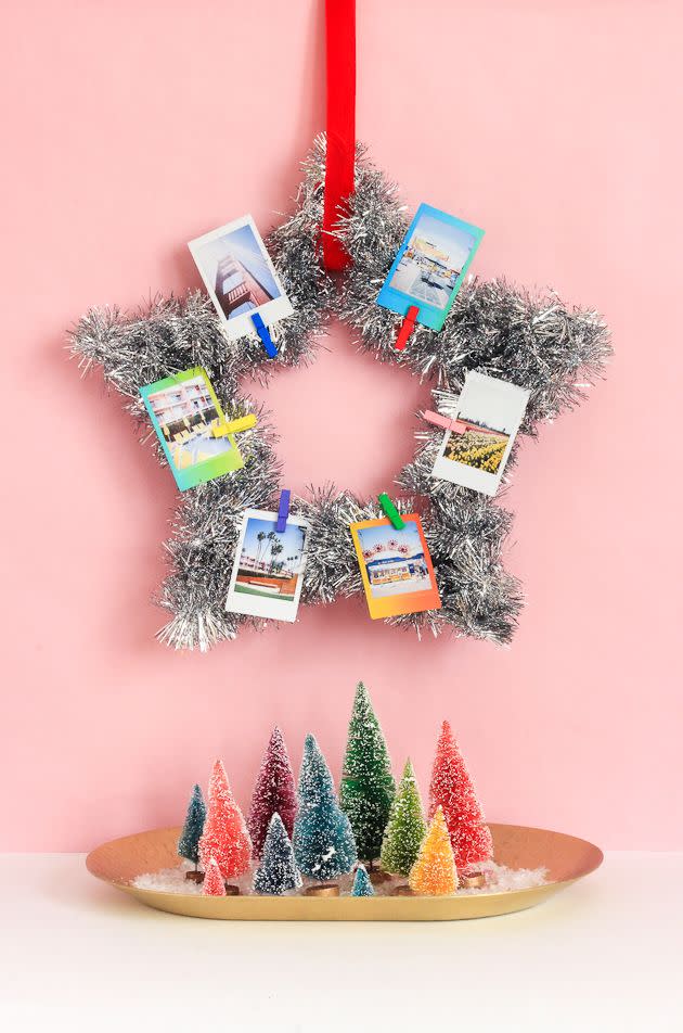 <p>Nothing says celebration like tinsel. This star wreath from <a href="https://thecraftedlife.com/diy-instax-tinsel-wreath/#more-13804" rel="nofollow noopener" target="_blank" data-ylk="slk:The Crafted Life;elm:context_link;itc:0;sec:content-canvas" class="link ">The Crafted Life</a> is easy to replicate—you just need to add your photos. Or you could put out a Polaroid camera at a holiday party and have everyone add their own photos in the moment. </p>