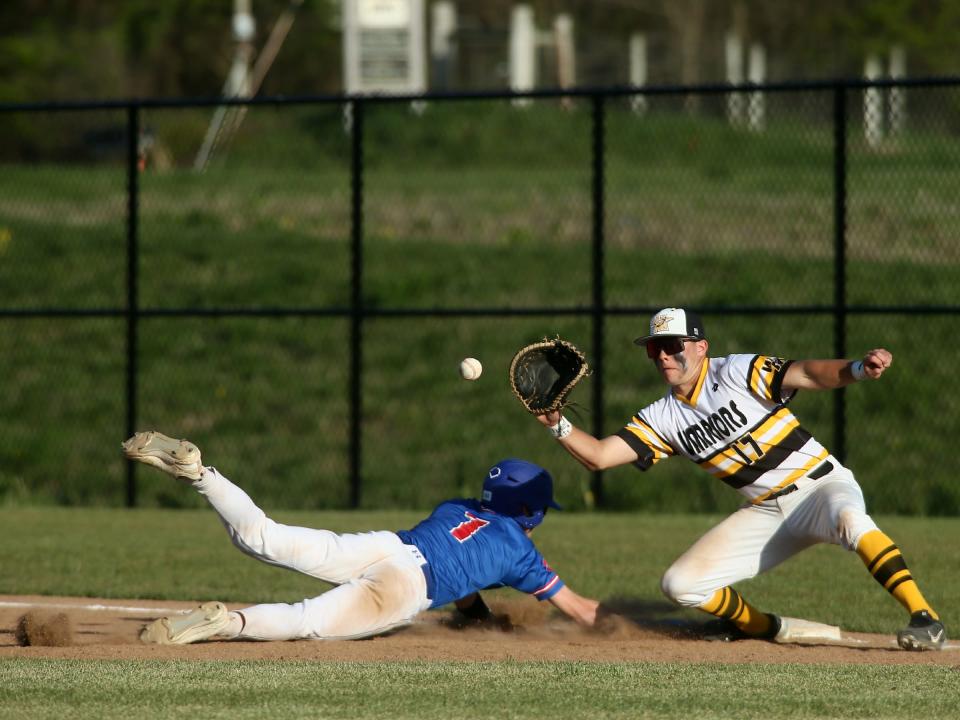 Licking Valley's Brody Rodgers slides safely to first as Watkins Memorial's Brayden Windnagel awaits the throw on Monday.