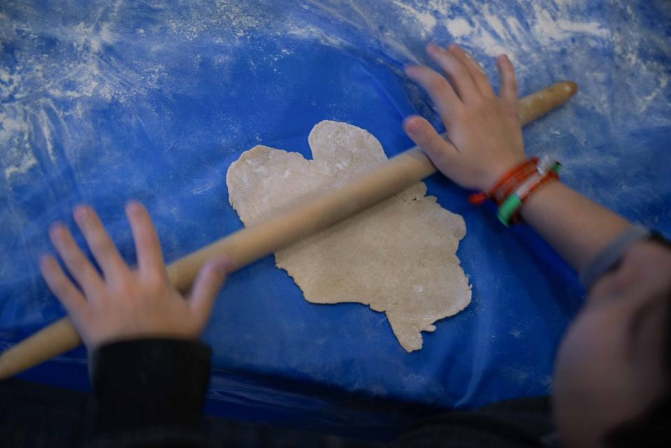 A child from Albert Einstein Academy rolls out fresh matzah for Passover in the Model Matzah Bakery in 2019.