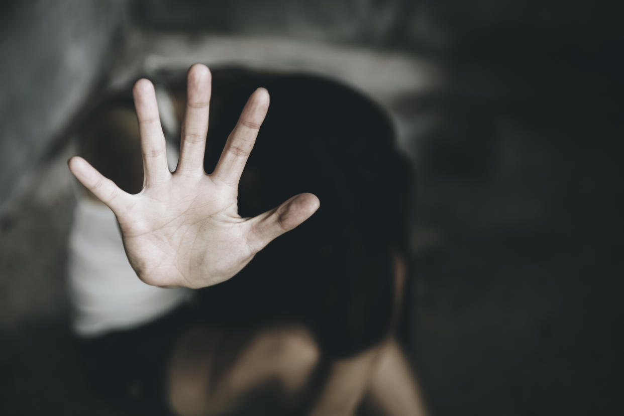 A woman crouched with her hand raised. (PHOTO: Getty Images)