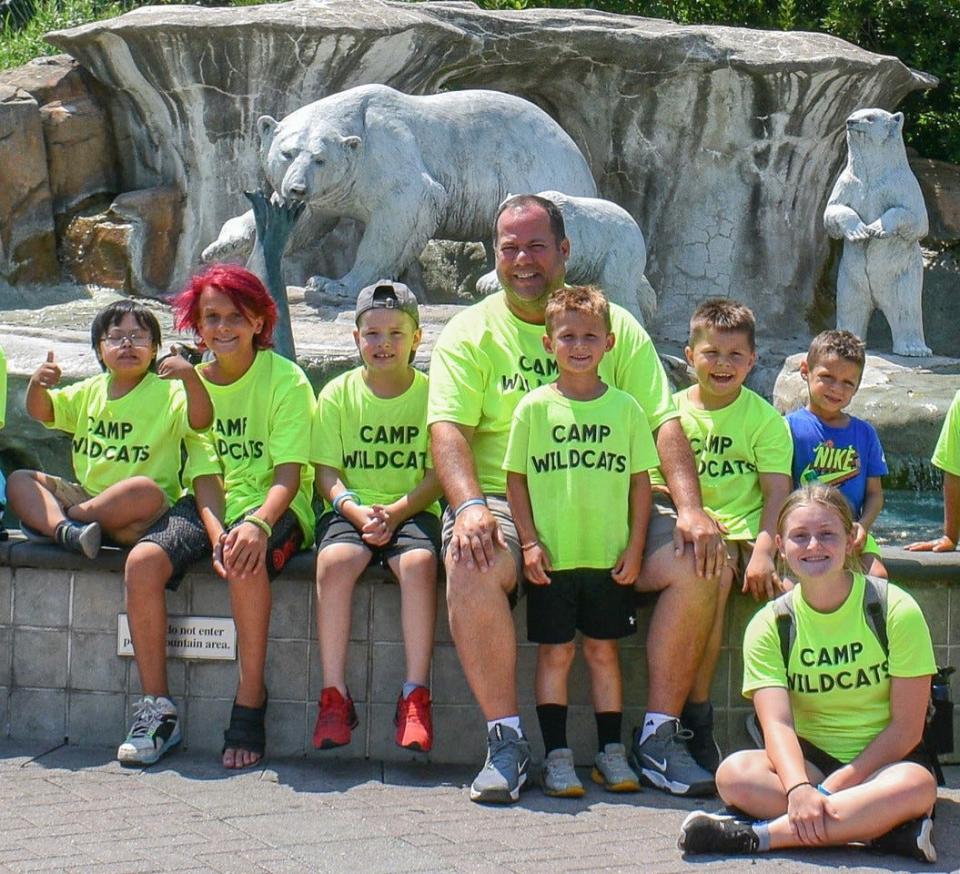 For one week each summer, Woodmore Middle School Principal Kevin Ball, shown here with a group of campers, creates fun memories with his students at Camp Wildcats.