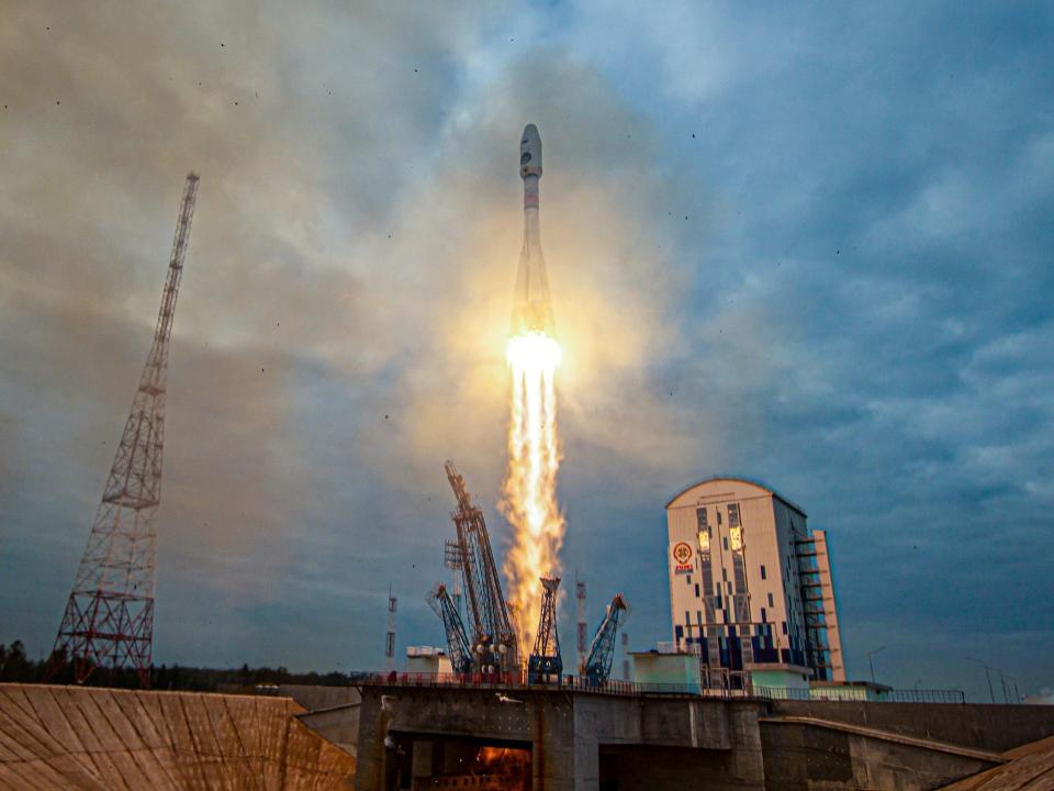 rocket launching into cloudy blue skies