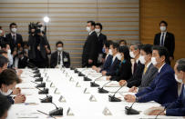 Japanese Prime Minister Shinzo Abe, right, declares a state of emergency during a meeting of the task force against the coronavirus at the his official residence in Tokyo, Tuesday, April 7, 2020. Abe declared a state of emergency for Tokyo and six other prefectures to ramp up defenses against the spread of the coronavirus. (Franck Robichon/Pool Photo via AP)