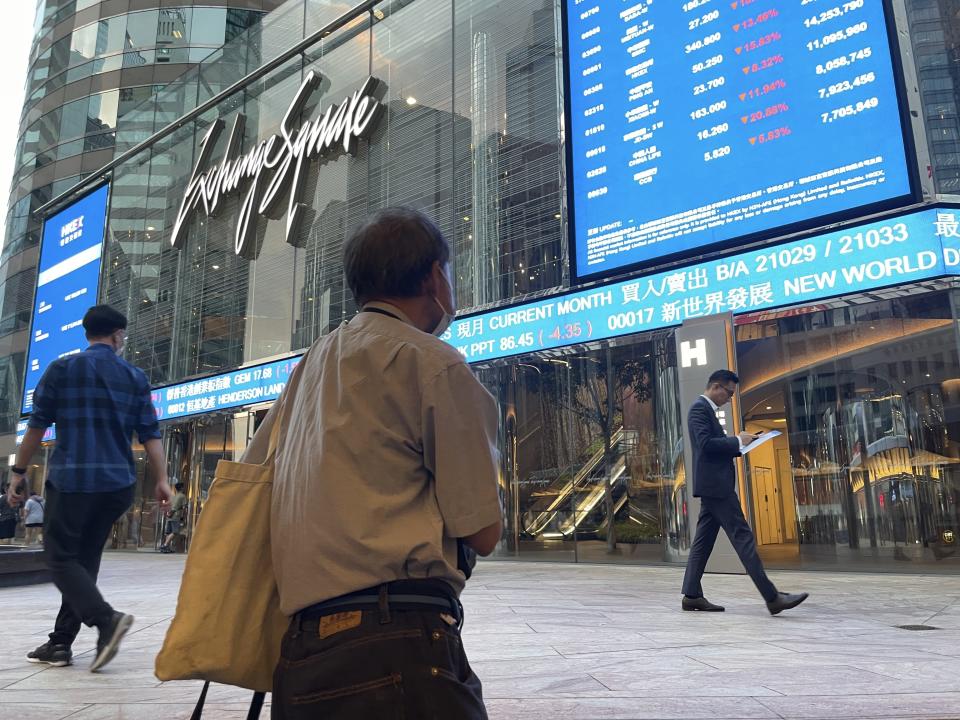 People walk past Hong Kong's stock exchange building as the market closed with a massive fall of more than nine percent in the benchmark Hang Seng Index on Tuesday, Oct. 8, 2024. (AP Photo)