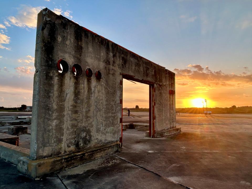 The sun sets beyond the lone remaining concrete wall of a support structure before the Jan. 27 Apollo 1 memorial ceremony begins at Launch Complex 34.
