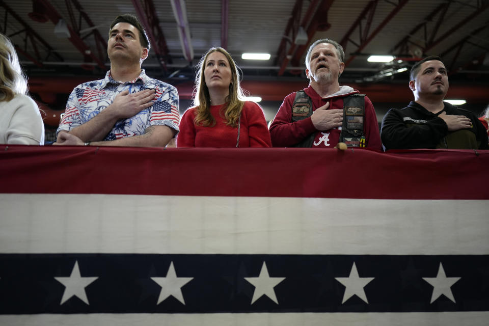 Supporters stand during the national anthem before a former President Donald Trump commit to caucus rally, Saturday, Jan. 6, 2024, in Clinton, Iowa. (AP Photo/Charlie Neibergall)