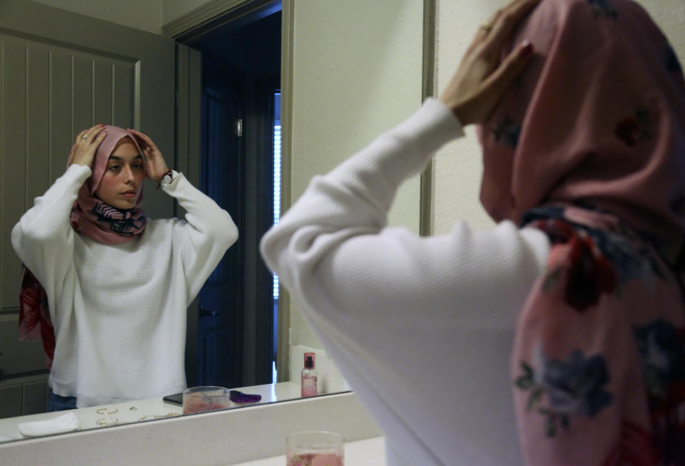 Amirah Ahmed, 17, adjusts her hijab before leaving for the grocery store on Saturday, Aug. 14, 2021, in Fredericksburg, Va. (AP Photo/Jessie Wardarski)