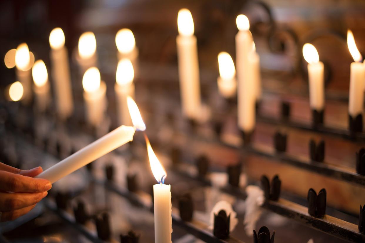 woman lighting prayer candle