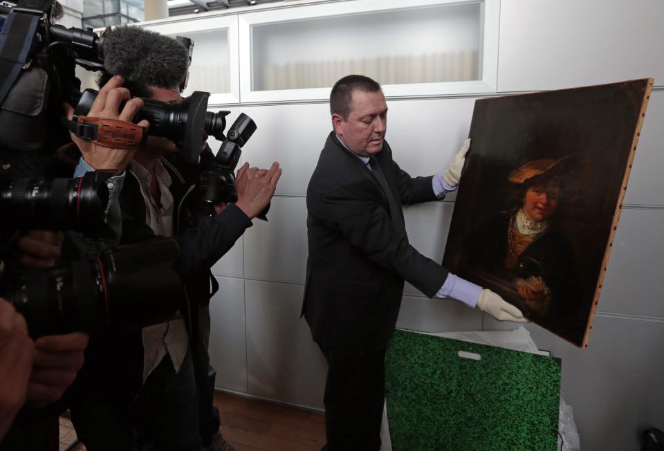 Colonel Stephane Goffeni holds the painting "L'enfant a la bulle de savon, 1630" (Child with a Soap Bubble) attributed to painter Rembrandt (1606-1669) during a presentation to journalists at a court in Nice March 20, 2014. The painting was stolen from a museum in Draguignan in southern France 15 years ago and has been recovered in Nice. REUTERS/Eric Gaillard (FRANCE - Tags: CRIME LAW SOCIETY MEDIA)