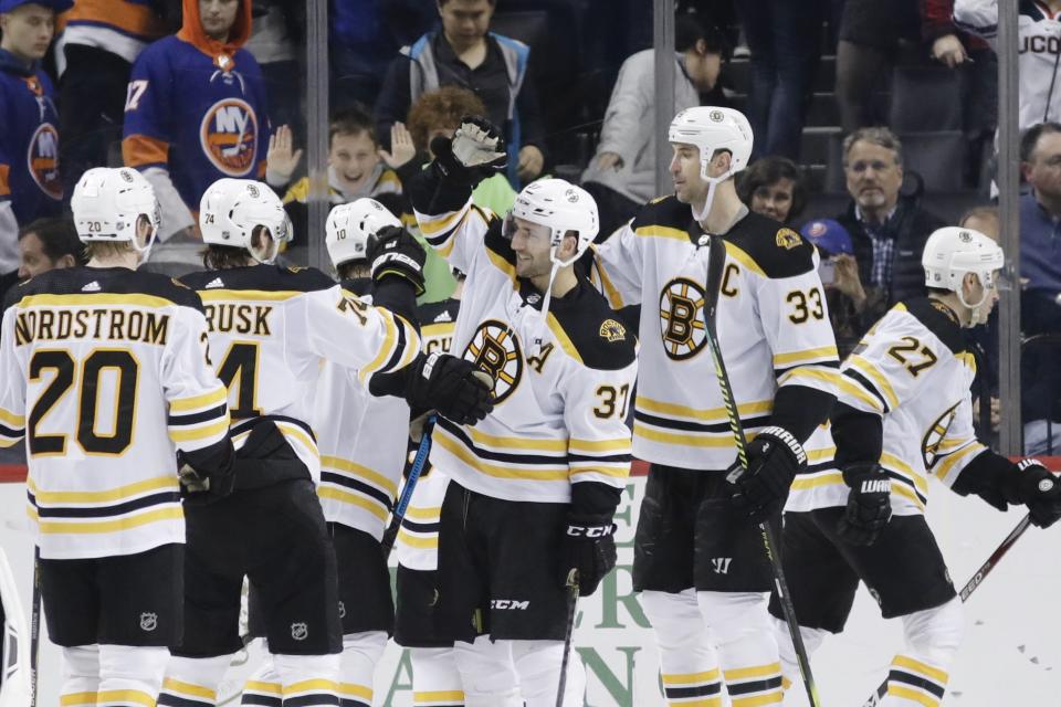 Boston Bruins' Patrice Bergeron (37) celebrates with teammates after scoring the winning goal during the overtime period of an NHL hockey game against the New York Islanders, Saturday, Jan. 11, 2020, in New York. (AP Photo/Frank Franklin II)