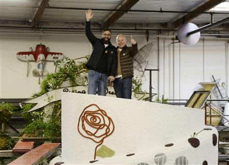 Danny Leclair (L) and Aubrey Loots stand on top of the wedding cake on the AIDS Healthcare Foundation (AHF) Tournament of Roses Parade parade float at Fiesta Parade Floats in Irwindale, California December 30, 2013. REUTERS/Kevork Djansezian