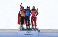 Freestyle Skiing - Pyeongchang 2018 Winter Olympics - Men's Ski Cross Finals - Phoenix Snow Park - Pyeongchang, South Korea - February 21, 2018 - Gold medallist Brady Leman of Canada celebrates on the podium with silver medallist Marc Bischofberger of Switzerland and bronze medallist Sergey Ridzik, an Olympic athlete from Russia, during the flower ceremony. REUTERS/Dylan Martinez