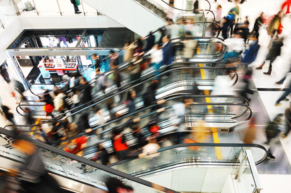 Multiple escalators inside a busy shopping mall.