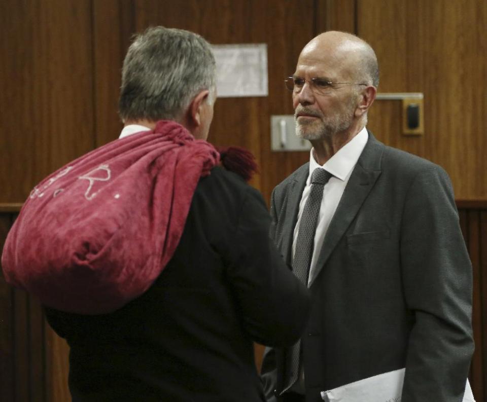 Arnold Pistorius, right, uncle of Oscar Pistorius talks with Oscar's lawyer Barry Roux, left, at the end the court session at the high court in Pretoria, South Africa, Monday, March 3, 2014. Pistorius is charged with murder for the shooting death of his girlfriend, Reeva Steenkamp, on Valentines Day in 2013. (AP Photo/Themba Hadebe, Pool)