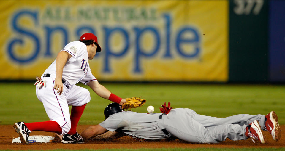 ARLINGTON, TX - OCTOBER 24: Matt Holliday #7 of the St. Louis Cardinals slides into second base safely ahead of the tag by Ian Kinsler #5 of the Texas Rangers after a wild pitch in the second inning during Game Five of the MLB World Series at Rangers Ballpark in Arlington on October 24, 2011 in Arlington, Texas. (Photo by Tom Pennington/Getty Images)