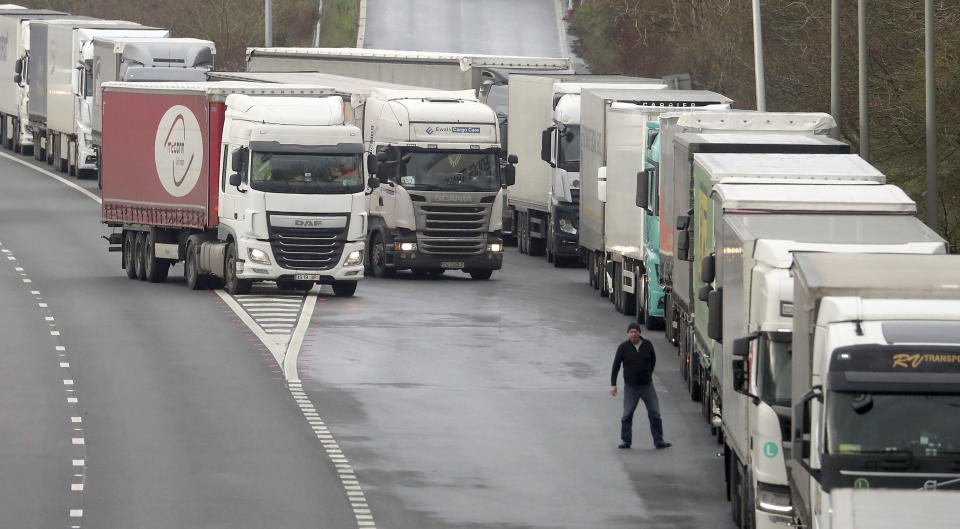 A lorry driver views the queue of lorries on the M20 as lorries wait to enter the Eurotunnel site due to heavy freight traffic as the clock ticks down on the chance for the UK to strike a deal before the end of the Brexit transition period on Dec. 31, in Folkestone, Kent, England, Friday, Dec. 18, 2020. (Gareth Fuller/PA via AP)