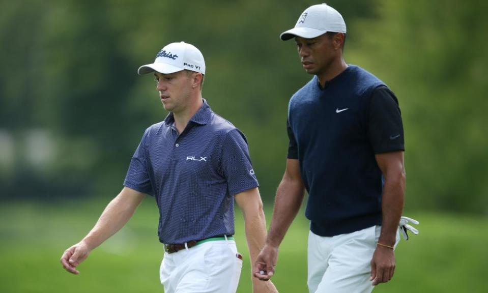 Justin Thomas (left) and Tiger Woods walk down the 12th fairway during the first round.