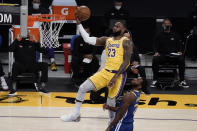 Los Angeles Lakers' LeBron James, top, goes up for a basket as Golden State Warriors' Andrew Wiggins watches during the first half of an NBA basketball game, Monday, Jan. 18, 2021, in Los Angeles. (AP Photo/Jae C. Hong)