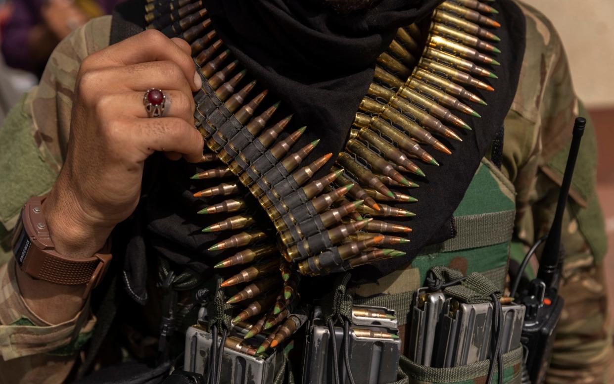 A heavily armed Taliban fighter guards the Afghanistan central bank in Kabul - NYTNS / Redux / eyevine