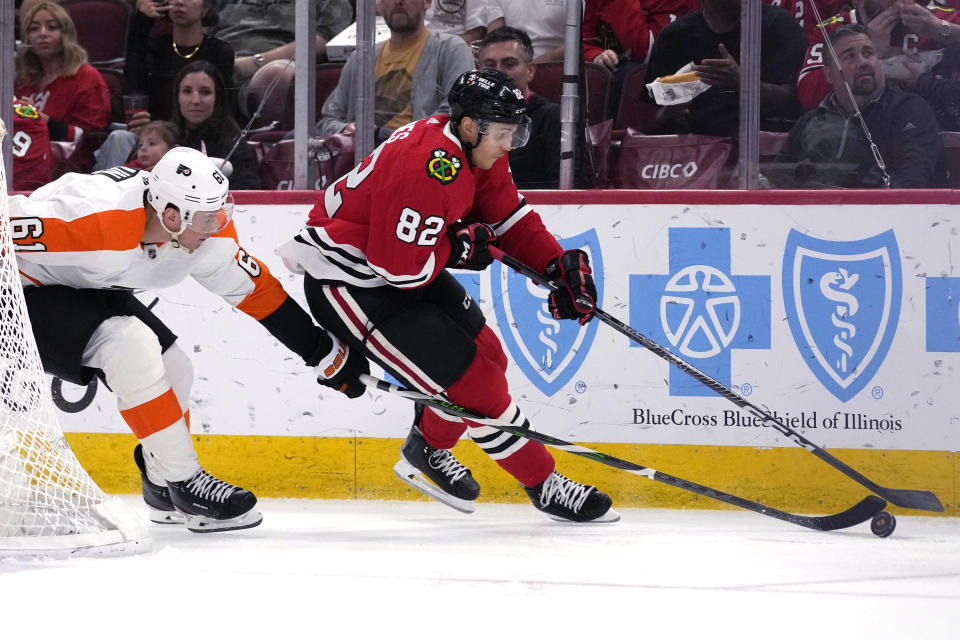 Philadelphia Flyers defenseman Justin Braun, left, controls the puck against Chicago Blackhawks defenseman Caleb Jones during the second period of an NHL hockey game in Chicago, Thursday, April 13, 2023. (AP Photo/Nam Y. Huh)