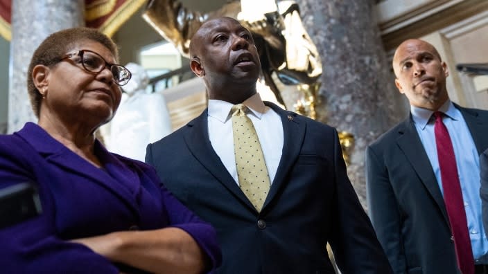 Lead bill negotiators (from left) Rep. Karen Bass, Sen. Tim Scott and Sen. Cory Booker speak briefly to reporters as they exit the office of Rep. James Clyburn following a meeting about police reform legislation. (Photo by Drew Angerer/Getty Images)