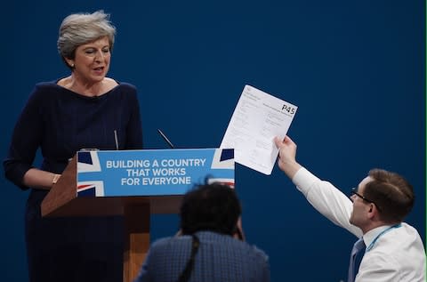 Comedian Simon Brodkin, aka prankster Lee Nelson, hands Theresa May a P45 during her keynote speech - Credit:  Carl Court/Getty Images Europe