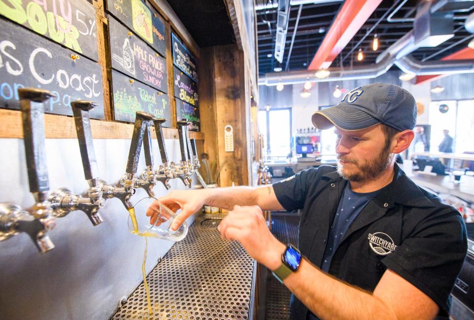 Josh Casey pours a beer at Switchyard Brewing in 2022. The bar will host Nerd Night, exploring AI, on Thursday.