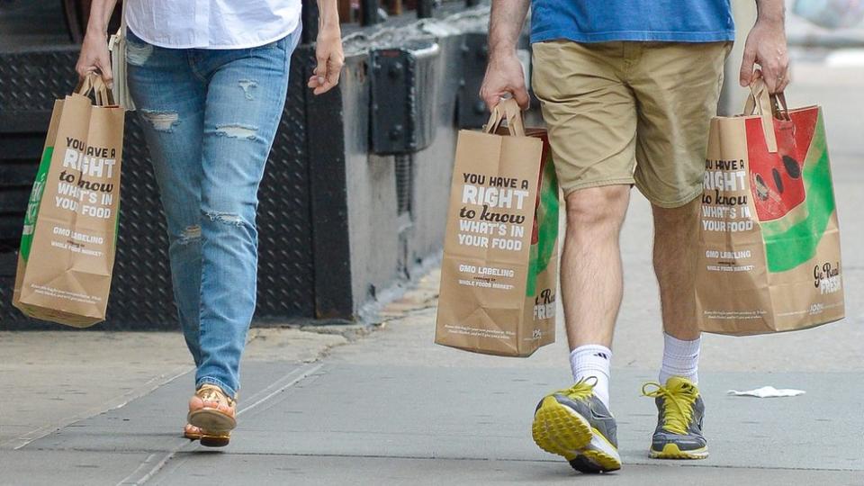 Personas cargan bolsas de papel