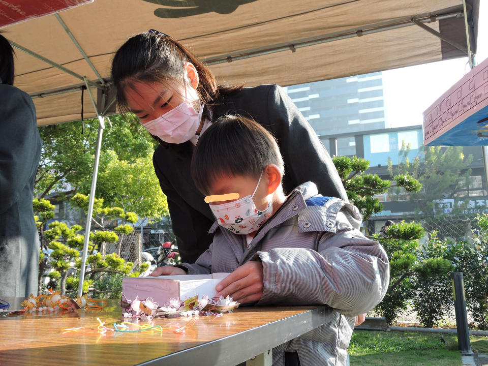 學生陪同歲末發放參與學童一起遊玩環保闖關活動。