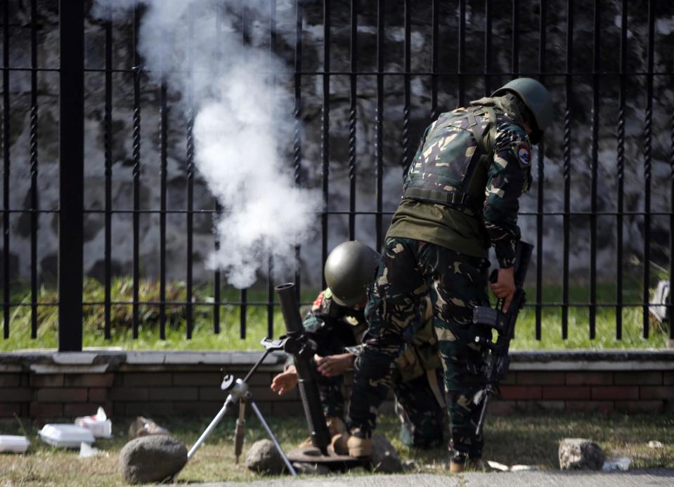 Government soldiers of Task Force Zamboanga (TFZ) fire a 60mm mortar round towards the Muslim rebels of Moro National Liberation Front (MNLF) positions in Zamboanga city in southern Philippines September 16, 2013. (REUTERS/Erik De Castro)