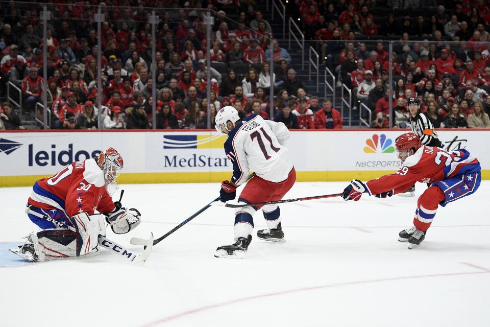 Columbus Blue Jackets left wing Nick Foligno (71) skates with the puck between Washington Capitals goaltender Ilya Samsonov (30), of Russia, and defenseman Christian Djoos (29) during the first period of an NHL hockey game Friday, Dec. 27, 2019, in Washington. (AP Photo/Nick Wass)