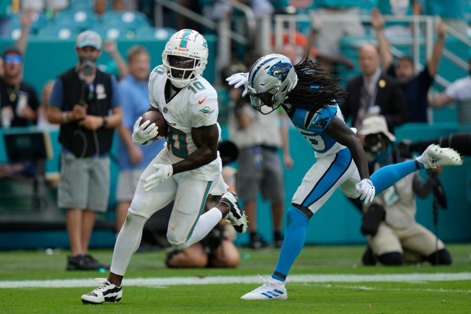 Miami Dolphins wide receiver Tyreek Hill (10) runs past Carolina Panthers cornerback Donte Jackson to score a touchdown during the first half of an NFL football game, Sunday, Oct. 15, 2023, in Miami Gardens, Fla.