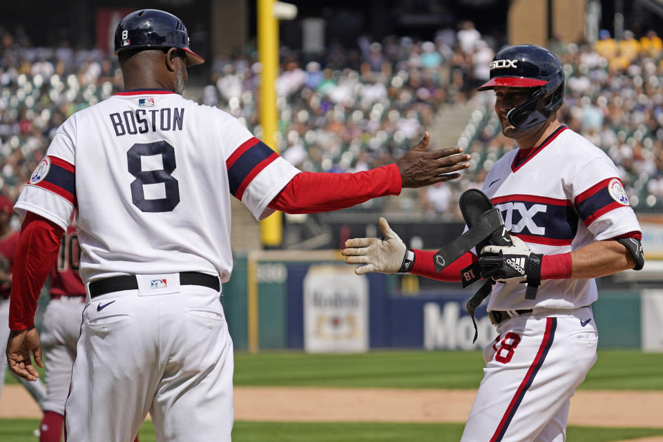 Chicago White Sox's AJ Pollock, right, celebrates with first base coach Daryl Boston after hitting a one-run single during the sixth inning of a baseball game against the Arizona Diamondbacks in Chicago, Sunday, Aug. 28, 2022. (AP Photo/Nam Y. Huh)