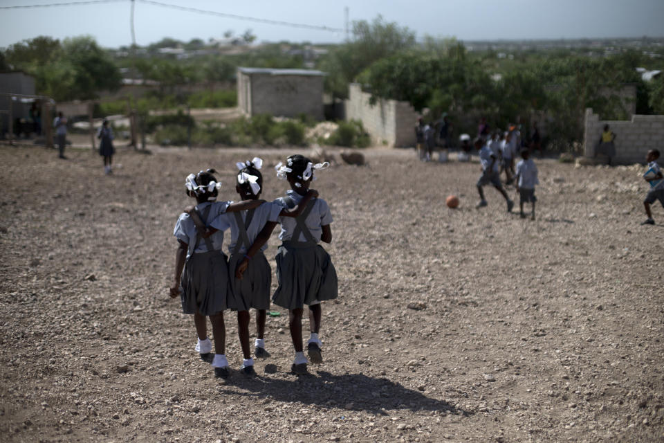 <p>Tres niñas caminan por el patio de la Escuela Evangélica Bethesda de Canaan (Haití). (Foto: Rebecca Blackwell / AP). </p>