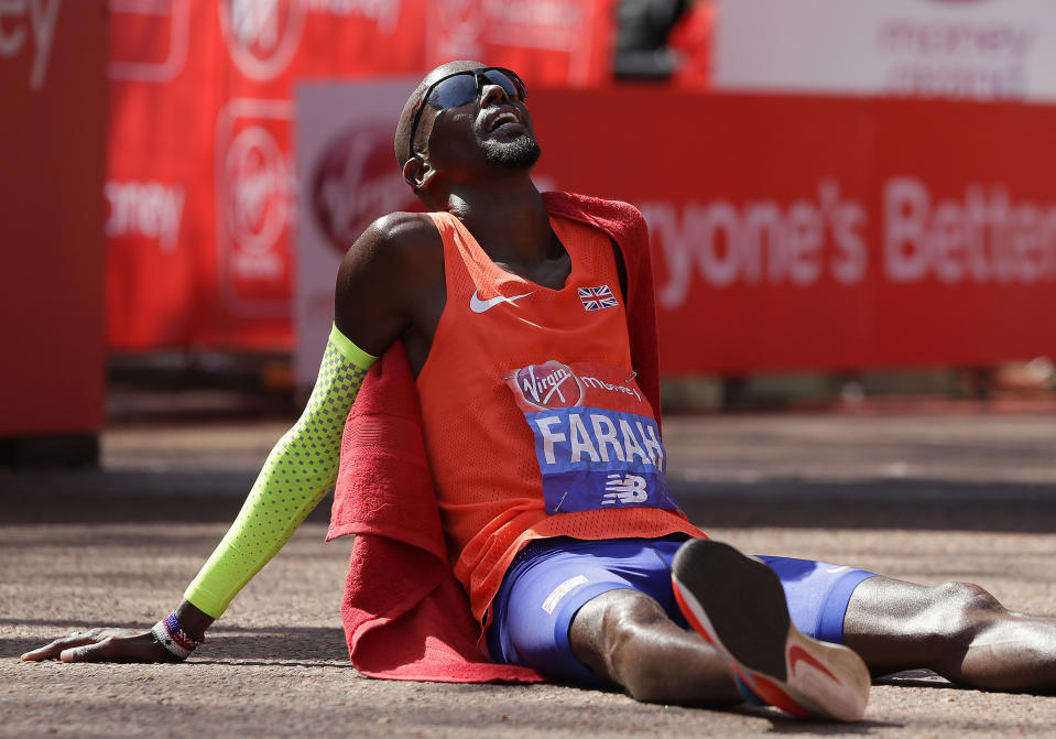 FILE - Britain's Mo Farah rests after crossing the finish line to place third in the Men's race in the London Marathon in central London, Sunday, April 22, 2018. It is hard to be first. Mo Farah this week went from being a gold medal-winning runner to the most prominent person ever to come forward as a victim of people trafficking. The four-time Olympic champion’s decision to tell the story of how he was exploited as a child gives a face to the often faceless victims of modern slavery, highlighting a crime that is often conflated with illegal immigration. (AP Photo/Kirsty Wigglesworth, FILE)