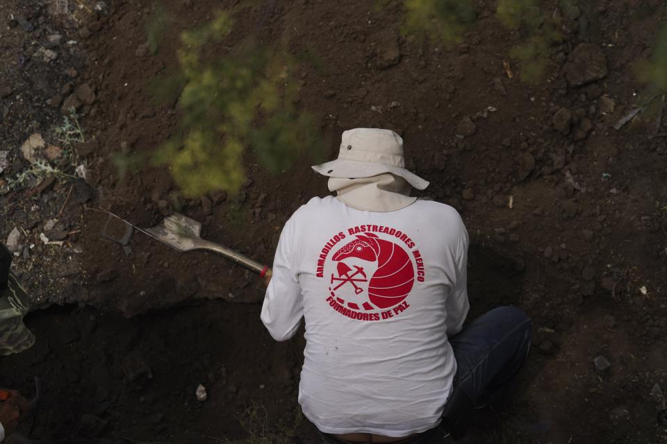 A relative searches for missing loved ones in a clandestine grave in Zumpango, Mexico, Friday, April 19, 2024. Hundreds of collectives searching for missing loved ones fanned out across Mexico on Friday as part of a coordinated effort to raise the profile of efforts that are led by the families of the tens of thousands of missing across Mexico without support from the government. (AP Photo/Marco Ugarte)