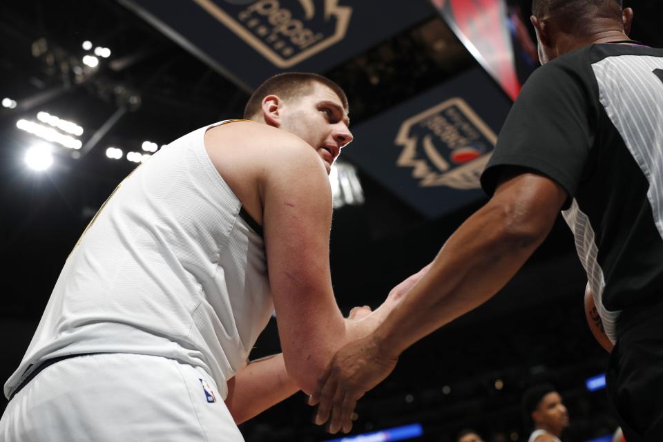 Denver Nuggets center Nikola Jokic, left, argues for a foul call with referee Michael Smith during the second half of Game 2 of the team's NBA basketball second-round playoff series against the Portland Trail Blazers on Wednesday, May 1, 2019, in Denver. Portland won 97-90. (AP Photo/David Zalubowski)