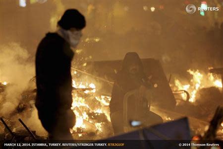 Anti-government protesters are seen behind a barricade that they set on fire, during a demonstration in Istanbul March 12, 2014. REUTERS/Serkan Senturk