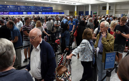 People queue with their luggage for the British Airways check-in desk at Gatwick Airport in southern England, Britain, May 28, 2017. REUTERS/Hannah McKay