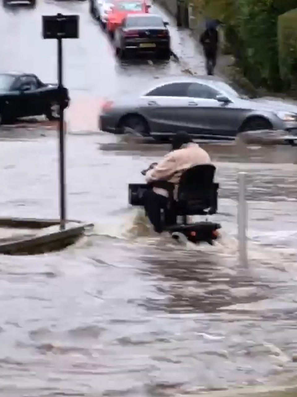 A person on a mobility scooter drives through floodwater in Woodseats, Sheffield as parts of England endured a month's worth of rain in 24 hours (Stephanie Jubb/Twitter/PA)