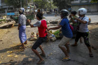 Anti-coup protesters armed with sling-shot and empty glass bottle reacts to charging riot policemen in Mandalay, Myanmar, Tuesday, March 2, 2021. Demonstrators in Myanmar took to the streets again on Tuesday to protest last month’s seizure of power by the military, as foreign ministers from Southeast Asian countries met to discuss the political crisis. Police in Yangon, Myanmar’s biggest city, used tear gas and rubber bullets against the protesters.(AP Photo)