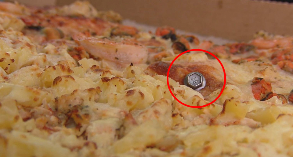 In this image a screw is seen inside a prawn and pineapple pizza from Bradman Pizza House in Cowandilla in Adelaide. 