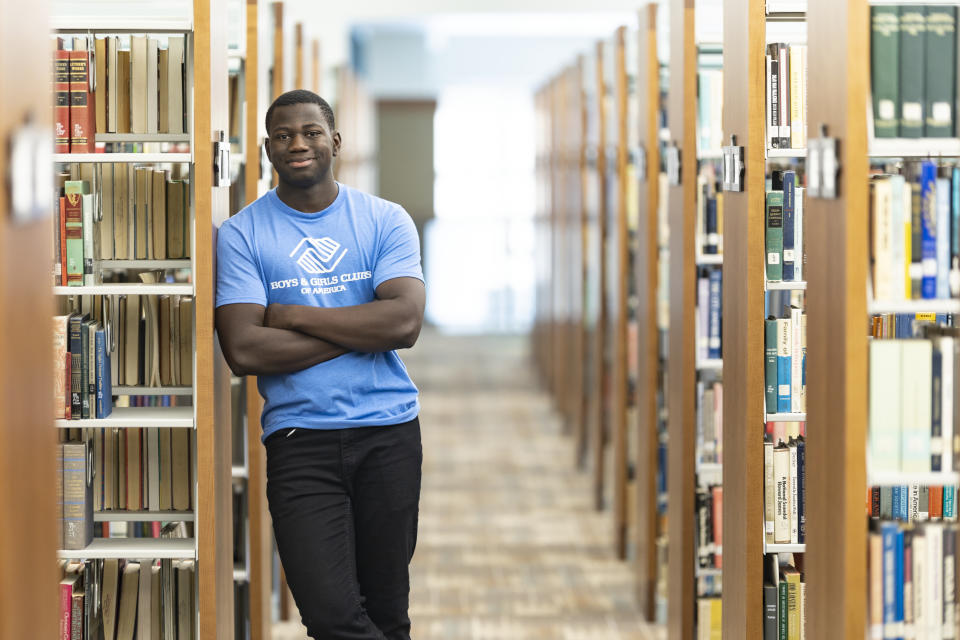 Steeve Biondolillo stands for a portrait in a library at Northwest Nazarene University in Nampa, Idaho on Friday, Oct. 7, 2022. Majoring in social work, he envisions a career working with the needy, helping to give back and nurture others. It has been a journey, he says, from “scared little kid to me, proud young man with big goals and a big future.’’ (AP Photo/Kyle Green)