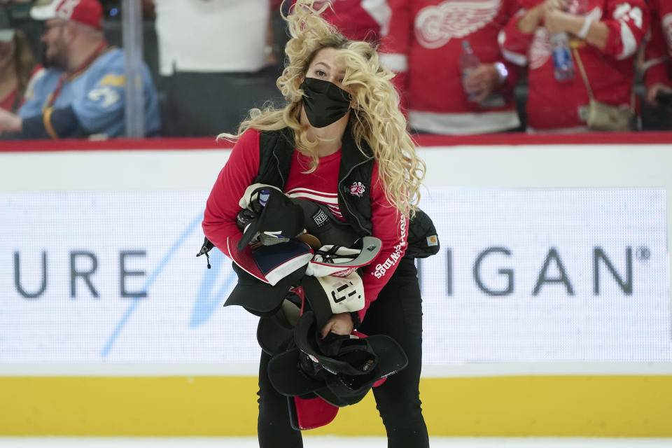 A member of the Detroit Red Wings ice crew collects hats after Tyler Bertuzzi's third goal for a hat trick against the Tampa Bay Lightning in the second period of an NHL hockey game Thursday, Oct. 14, 2021, in Detroit. (AP Photo/Paul Sancya)