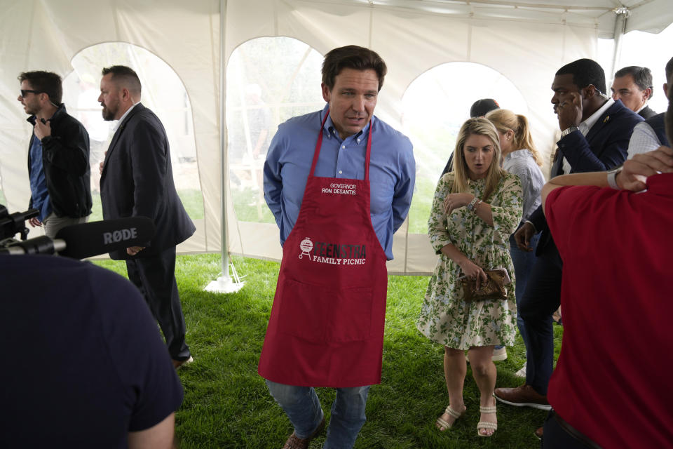 Florida Gov. Ron DeSantis takes off an apron after working the grill at a fundraising picnic for U.S. Rep. Randy Feenstra, R-Iowa, Saturday, May 13, 2023, in Sioux Center, Iowa. (AP Photo/Charlie Neibergall)