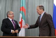 Russia's Foreign Minister Sergei Lavrov (R) shakes hands with his Algerian counterpart Ramtane Lamamra during a news conference in Moscow February 11, 2014. Lavrov said on Tuesday that a draft U.N. Security Council resolution aimed boost aid access to Syria was one-sided and detached from reality, the Interfax news agency reported. (REUTERS/Maxim Shemetov)