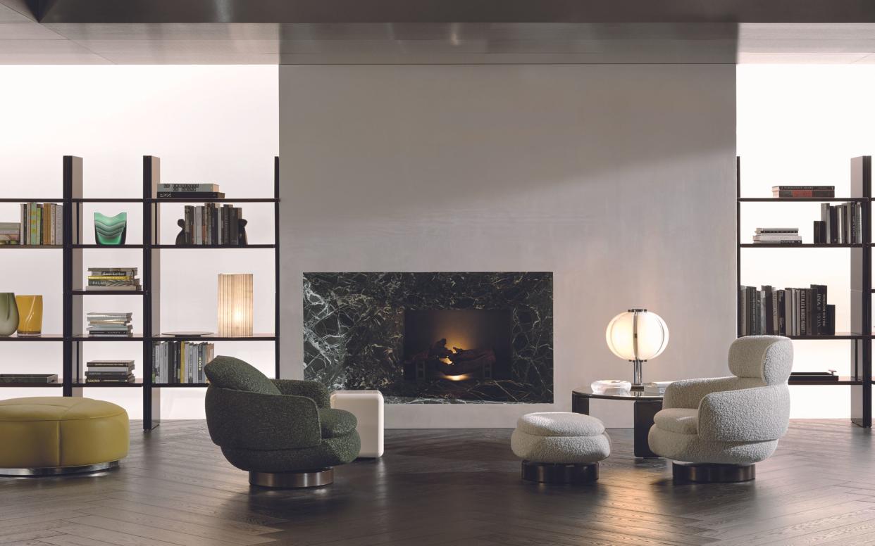  Milan Design Week Minotti 2 accent chairs, green and white in large living room with bookshelves. 